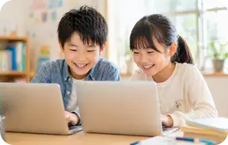 一緒にパソコンを見る子どもたち