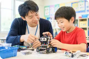 講師と一緒にロボットを組み立てる子ども